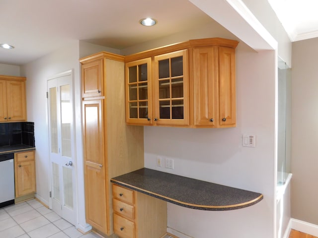 kitchen featuring glass insert cabinets, dark countertops, stainless steel dishwasher, and built in study area