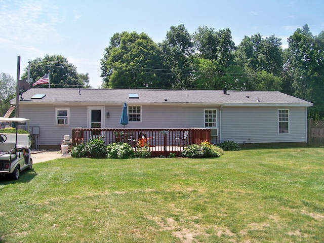 back of property with a yard and a wooden deck