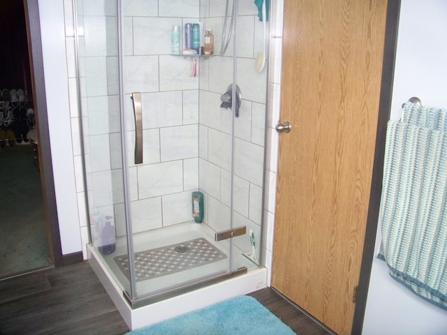 full bath with a shower stall and wood finished floors