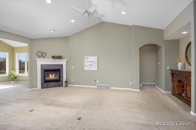 unfurnished living room featuring a tiled fireplace, visible vents, and carpet