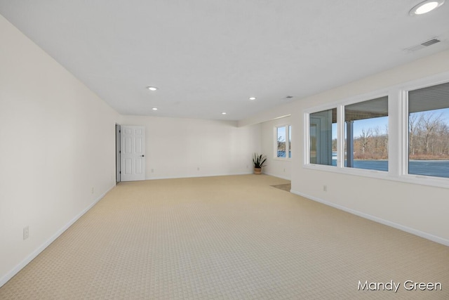 empty room featuring recessed lighting, light colored carpet, visible vents, and baseboards