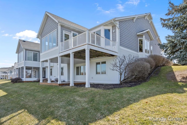 rear view of house featuring a deck and a lawn