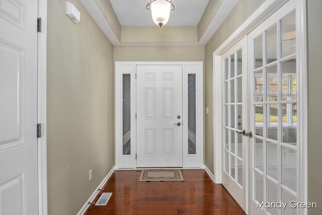 doorway with visible vents, baseboards, wood finished floors, and french doors