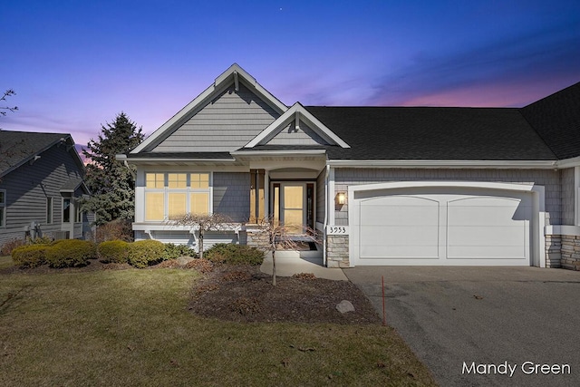 view of front facade with stone siding, driveway, a front lawn, and a garage