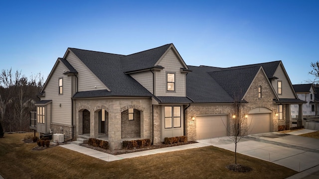 view of front of home with a front lawn, concrete driveway, a garage, and roof with shingles