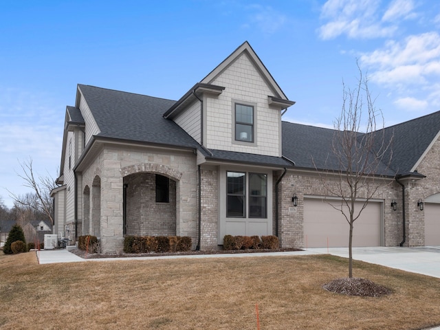 view of front of property featuring brick siding, a garage, a front lawn, and driveway