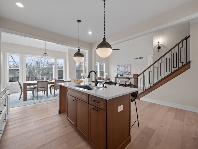 kitchen with visible vents, light countertops, light wood-style floors, and a sink