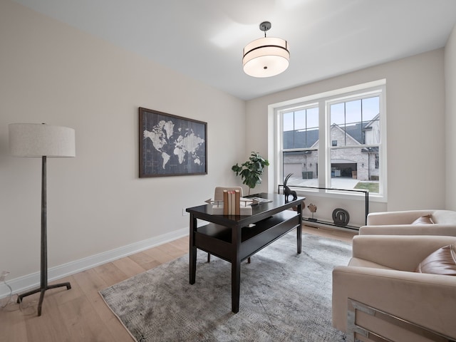 office area with light wood-style flooring and baseboards