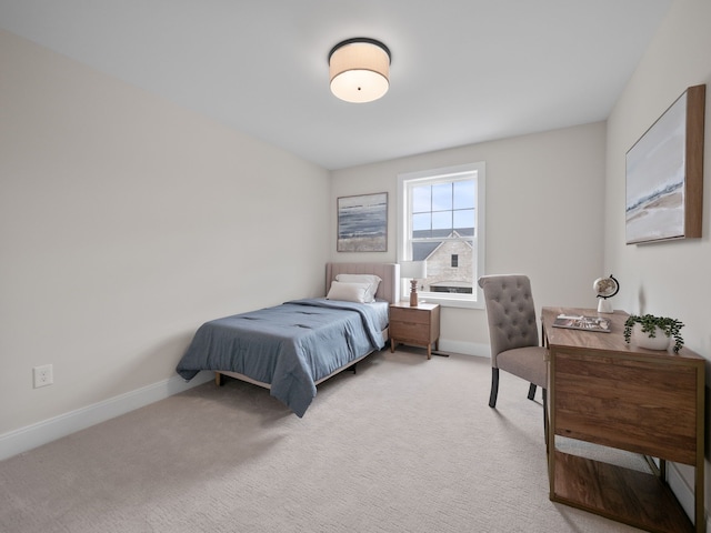 bedroom with light colored carpet and baseboards