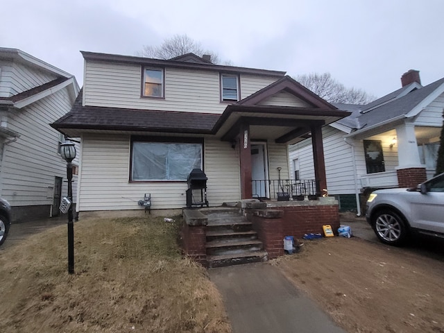 view of front of home featuring covered porch and a shingled roof