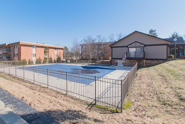 pool with a patio area and fence