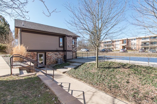 view of yard featuring a fenced in pool, central air condition unit, and fence