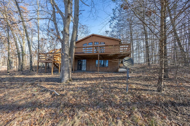 back of property with a deck and stairs