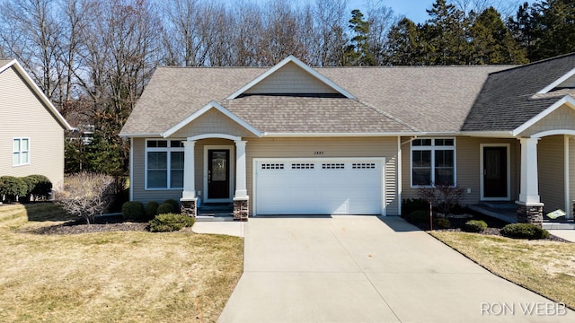 craftsman inspired home with concrete driveway, an attached garage, a front yard, and a shingled roof