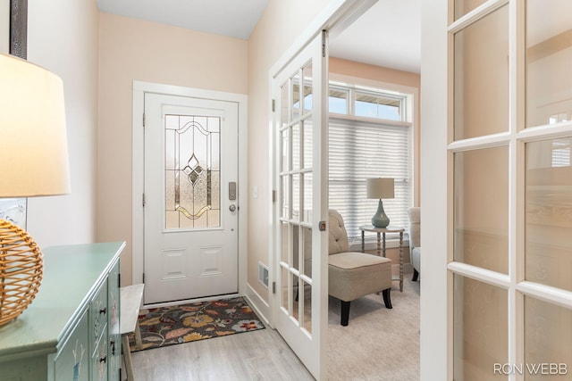 doorway to outside with french doors, light wood-style floors, and visible vents