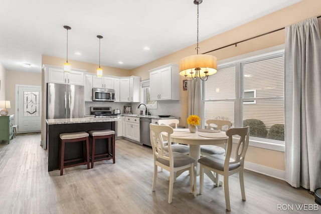 dining room featuring recessed lighting, baseboards, and light wood-style flooring