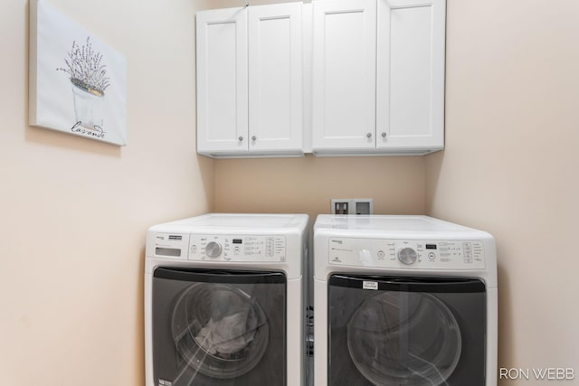 laundry area featuring washer and clothes dryer and cabinet space