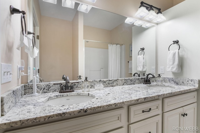 bathroom featuring a sink and double vanity