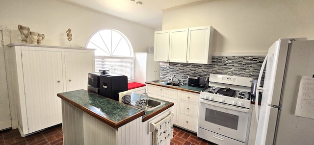 kitchen with dark countertops, white appliances, brick floor, and a sink