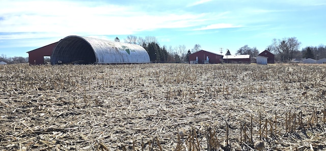 view of yard with an outbuilding and a rural view