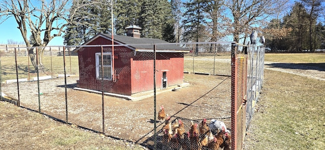 view of side of property featuring exterior structure, fence, a yard, an outdoor structure, and a chimney