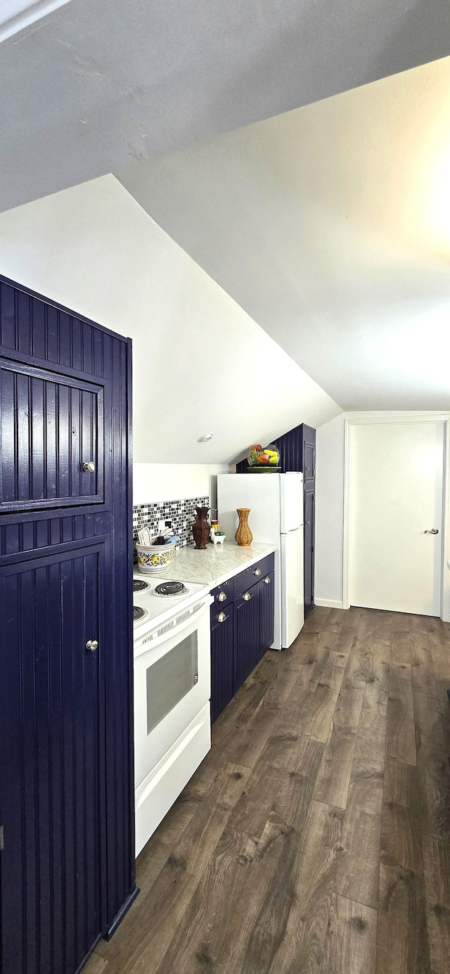 kitchen featuring blue cabinetry, white appliances, lofted ceiling, and dark wood-style flooring