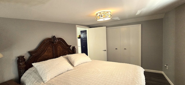 bedroom with a closet, baseboards, and dark wood-style flooring