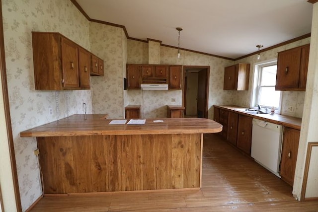 kitchen with under cabinet range hood, vaulted ceiling, wallpapered walls, and white dishwasher