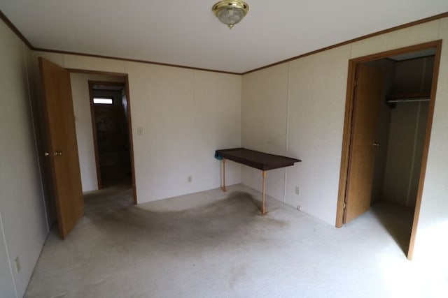 unfurnished bedroom featuring light carpet and crown molding