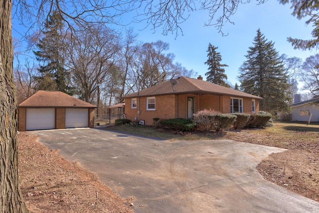 single story home with brick siding, a garage, a chimney, and an outdoor structure