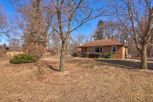 view of front of property featuring brick siding and a chimney