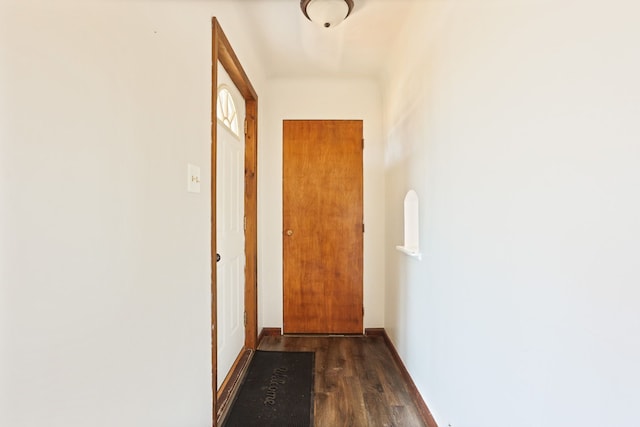 hall with baseboards and dark wood-style flooring