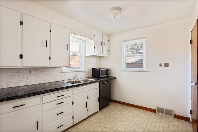 kitchen featuring visible vents, a sink, stainless steel microwave, black dishwasher, and decorative backsplash