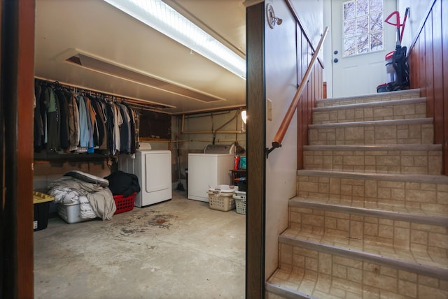 staircase featuring concrete floors and washing machine and clothes dryer