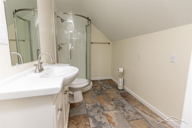 bathroom with a shower stall, stone finish flooring, baseboards, toilet, and vanity