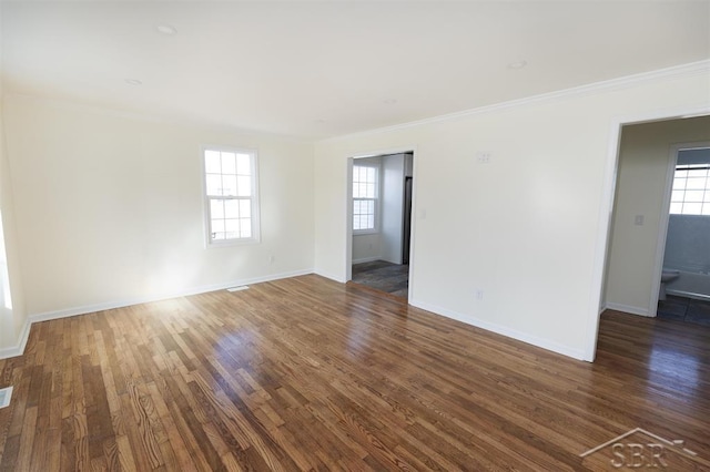 spare room featuring wood finished floors, baseboards, and ornamental molding