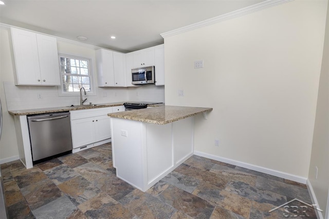 kitchen with stainless steel appliances, baseboards, and a sink