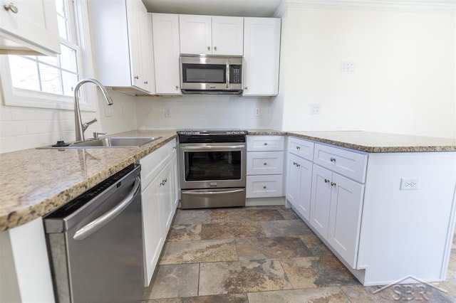 kitchen featuring a sink, a peninsula, white cabinetry, and stainless steel appliances