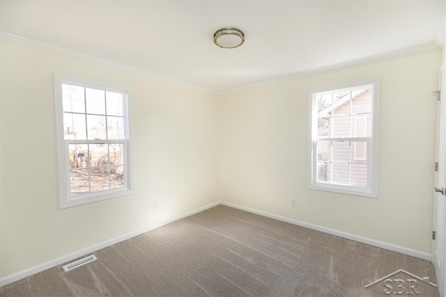 unfurnished room with visible vents, carpet flooring, crown molding, and baseboards