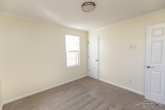 carpeted empty room featuring crown molding and baseboards