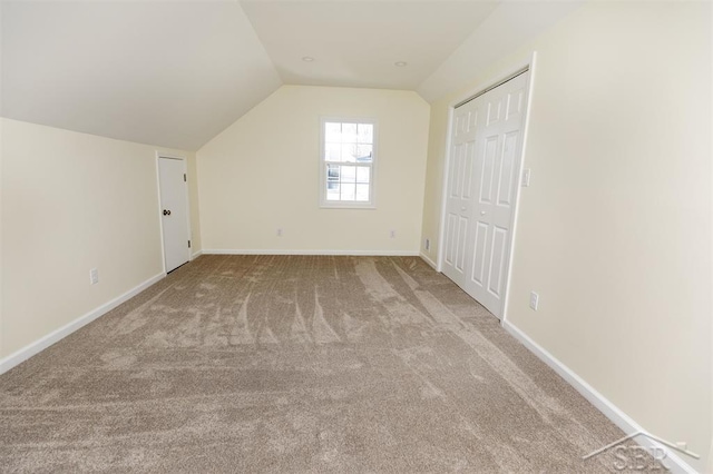 additional living space featuring baseboards, lofted ceiling, and carpet floors