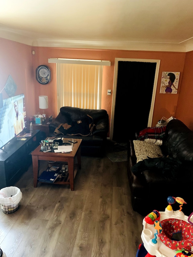 living room with wood finished floors and ornamental molding