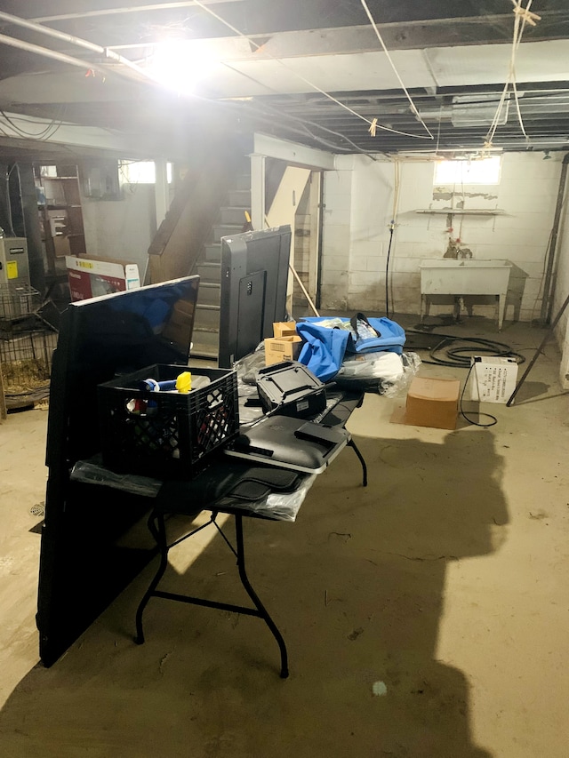 basement featuring stairs and a sink