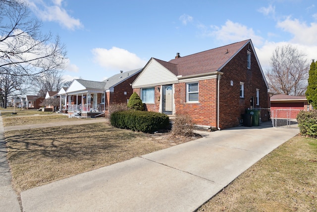 view of front of home featuring brick siding, covered porch, and concrete driveway