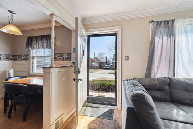 interior space with visible vents, wood finished floors, and ornamental molding