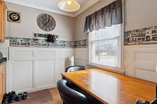 office area featuring crown molding, visible vents, a wainscoted wall, and light wood-type flooring