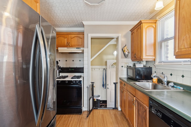 kitchen featuring black appliances, ornamental molding, a sink, under cabinet range hood, and an ornate ceiling