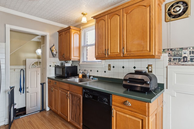 kitchen featuring a sink, black appliances, light wood-style floors, crown molding, and brown cabinets