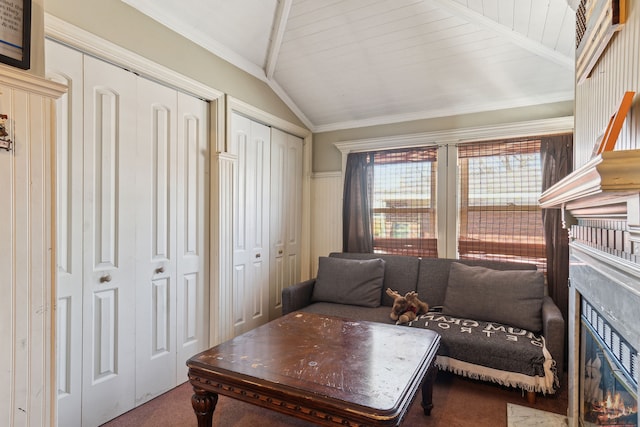 living room with a high end fireplace, lofted ceiling, ornamental molding, and carpet flooring