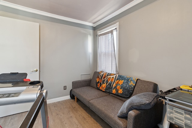 living area with baseboards, light wood-type flooring, and ornamental molding